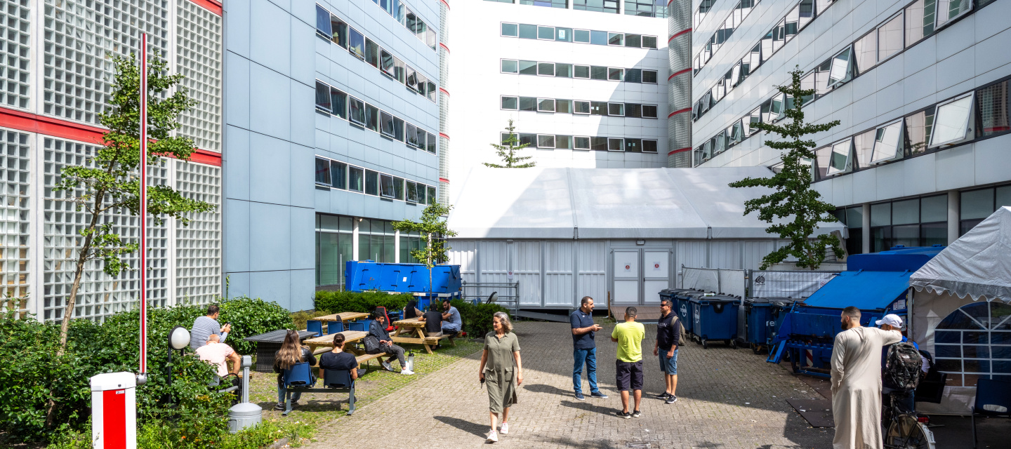mensen buiten noodopvang gebouw