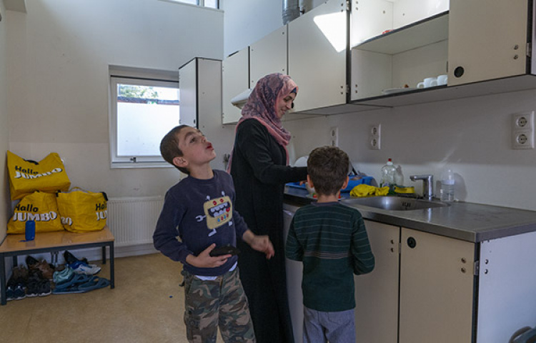 Vrouw met twee kinderen in hun kamer in het azc