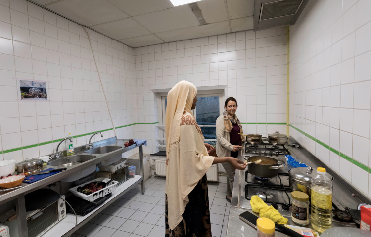 Asielzoekers koken in de gemeenschappelijke keuken van het azc