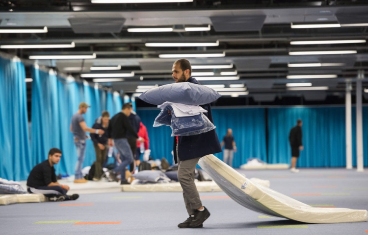 Vluchteling sleept met een matras in Jaarbeurs Utrecht