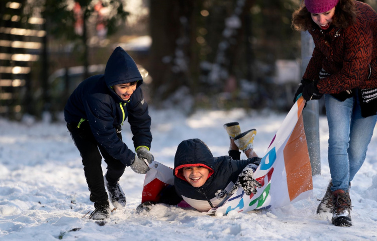 Asielzoekersinderen spelen buiten in de sneeuw