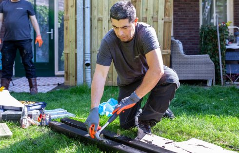 man met een spijker in zn hand, aan het werk