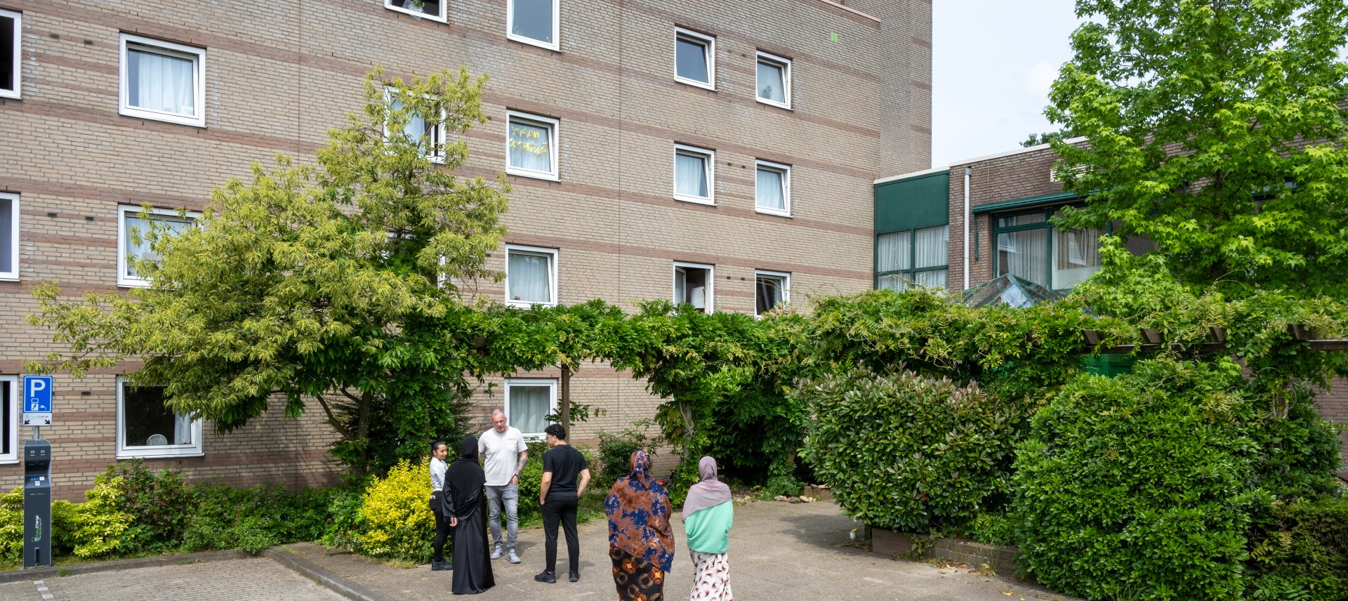Flatgebouw met asielzoekers en medewerkers voor de ingang
