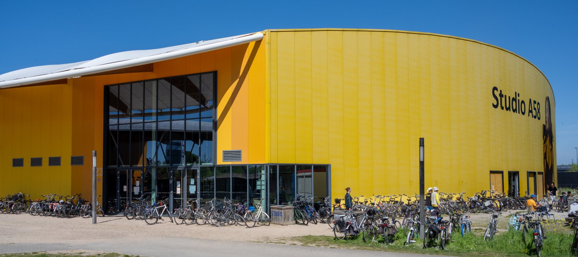 gebouw van coa locatie middelburg studio A58, het gebouw is geel en er staan veel fietsen voor.