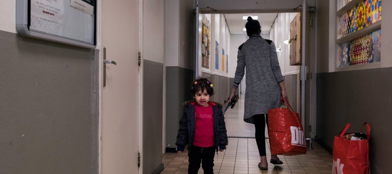 Moeder en kind met boodschappen in het azc 