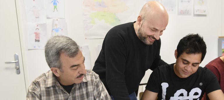 Programmabegeleider COA helpt statushouders tijdens les Kennis van de Nederlandse Maatschappij