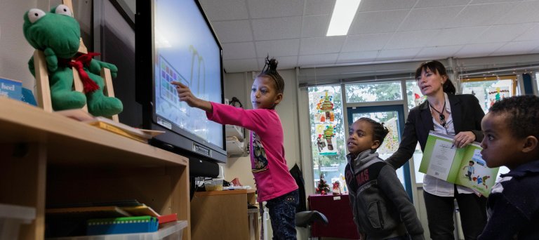Asielzoekerskinderen bij het digibord op school