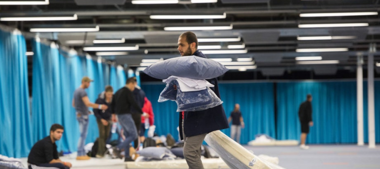 Vluchteling sleept met een matras in Jaarbeurs Utrecht