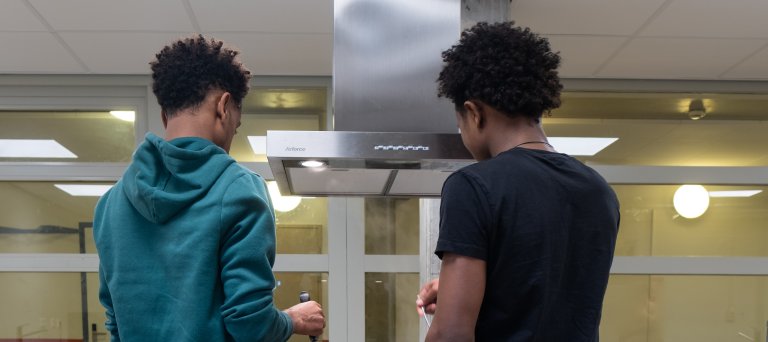 2 jongeren zijn aan het koken in een azc