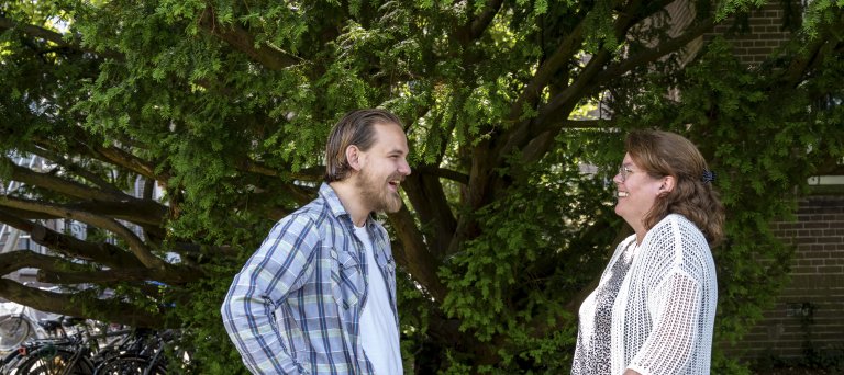 Geïnterviewden Luuk en Jolanda poseren voor een boom