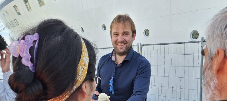 man deelt ijs uit aan azc-bewoners