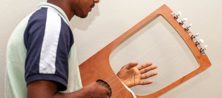 jongen speelt soort van harp