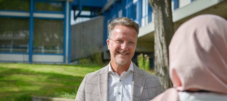 man kijkt vrouw, ze staan bij een azc