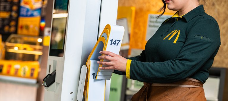 Vrouw plaatst bordje in fastfoodketen