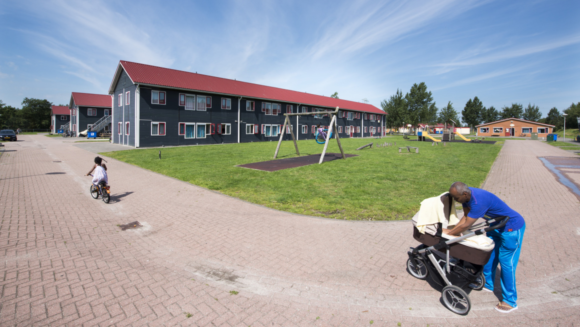 Man met kinderwagen en fietsend meisje bij gezinslocatie Burgum