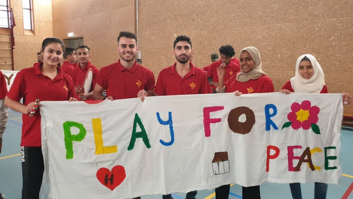 jongeren met Play for Peace spandoek