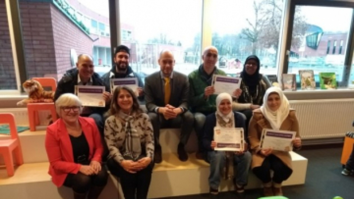 groep mensen poseert met certificaat