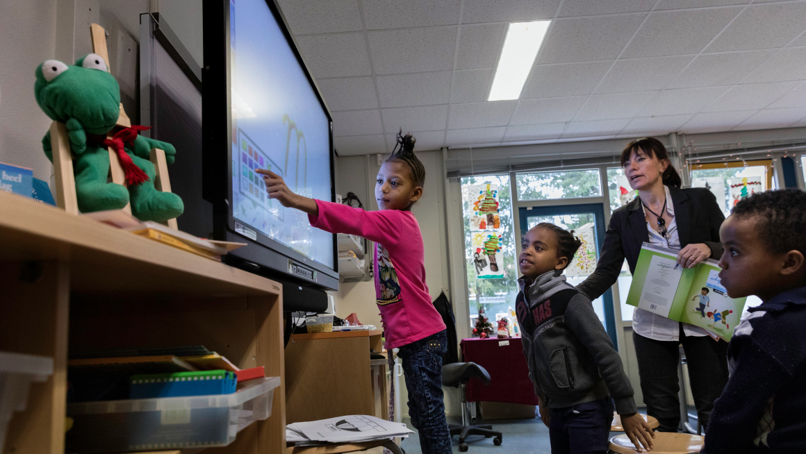 Asielzoekerskinderen bij het digibord op school