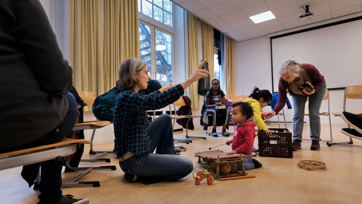 Kinderen doen mee aan een muziekactiviteit in het azc