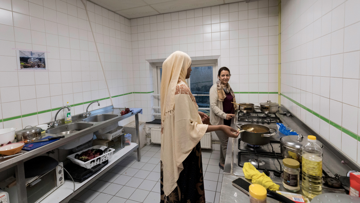 Twee vrouwen koken in de gemeenschappelijke keuken in het azc