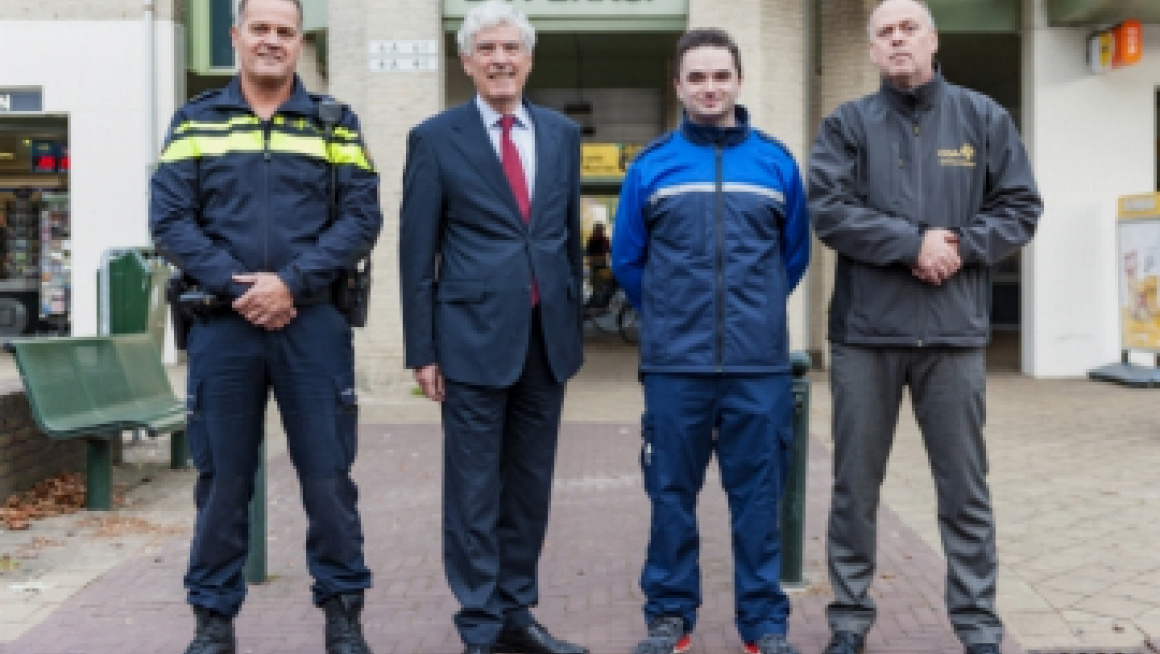 Burgemeester Henri de Wijkerslooth geflankeerd door BOA, politie en COA