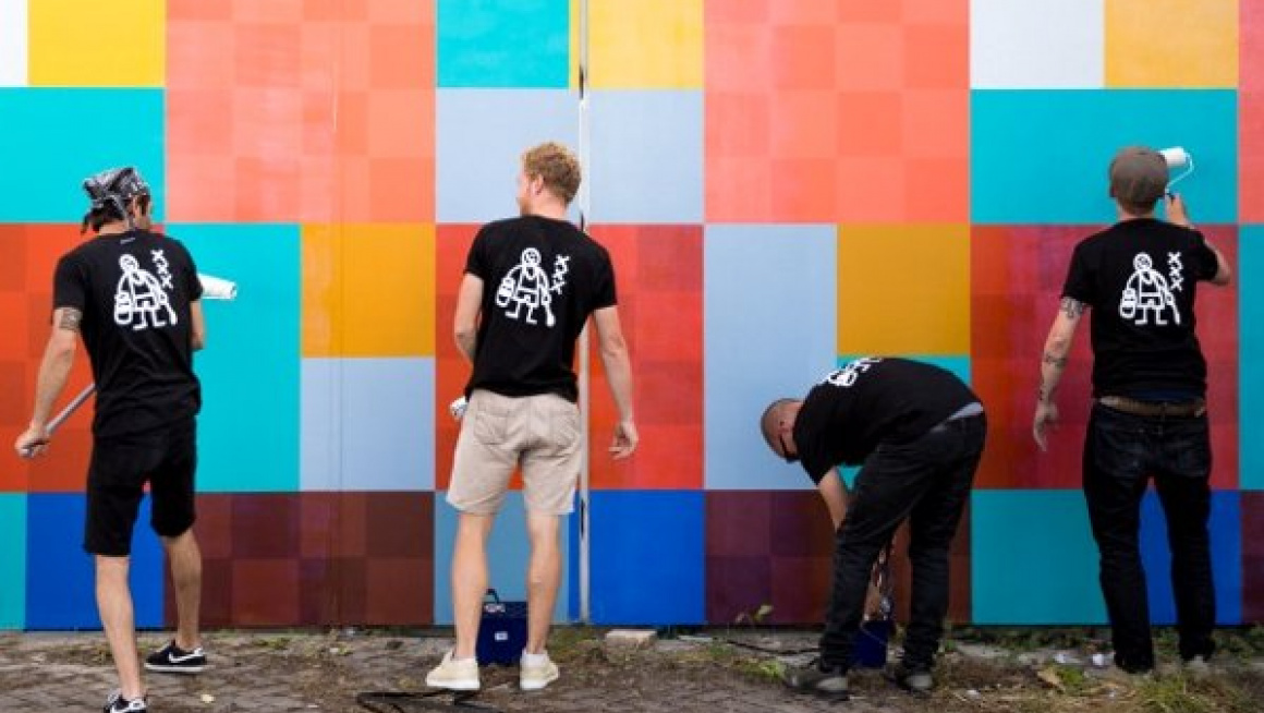 muur wordt geschilderd door een paar jongens