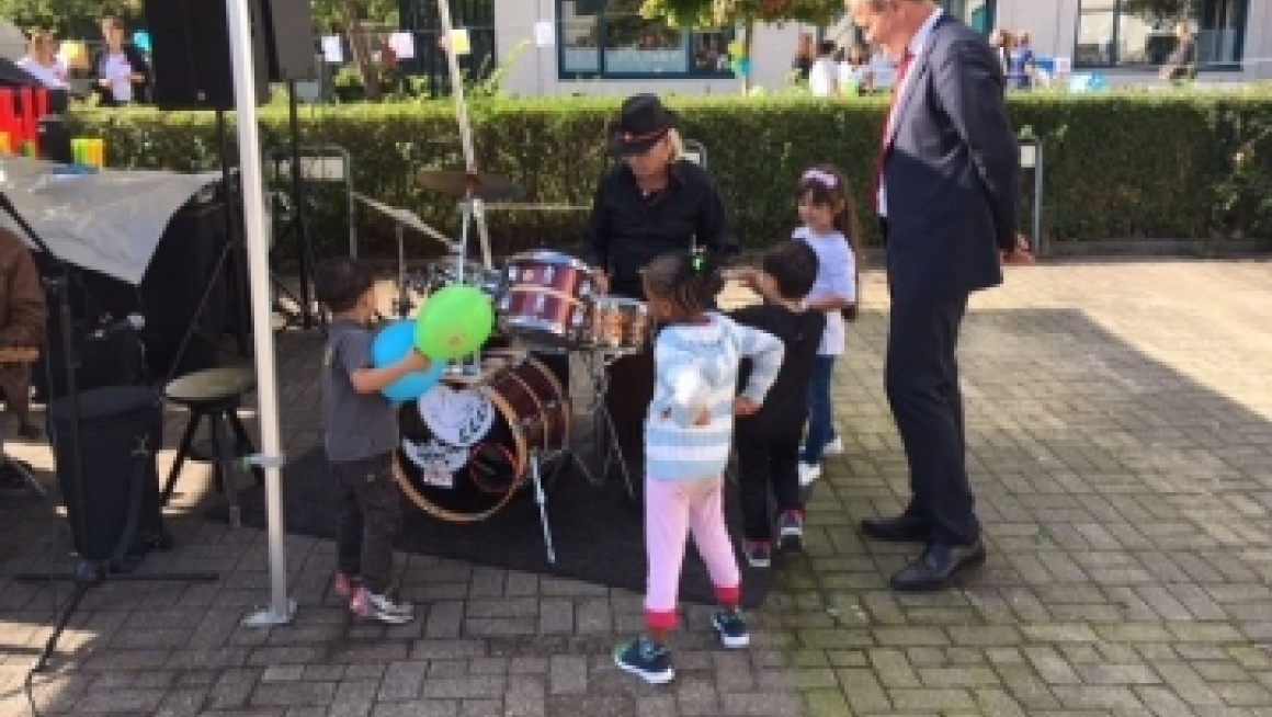 mensen staan om een muzikant heen met drumstel