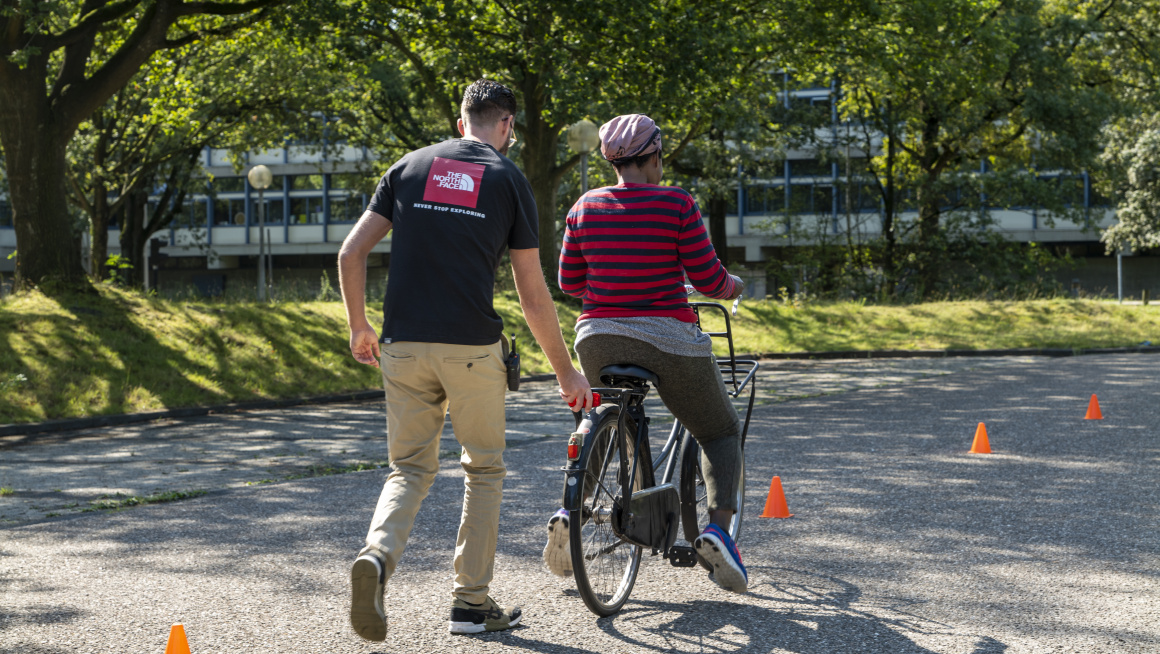 man helpt vrouw bij fietsen