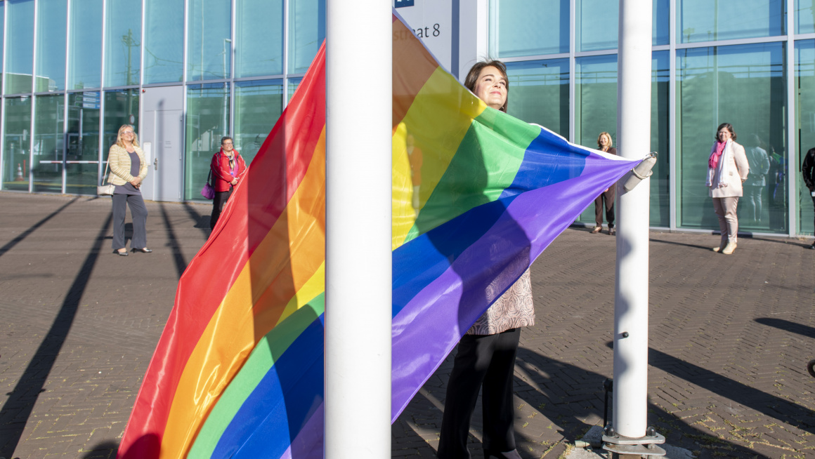 Bahia Tahzib-Lie hangt de Regenboogvlag op bij de Rijnstraat in Den Haag