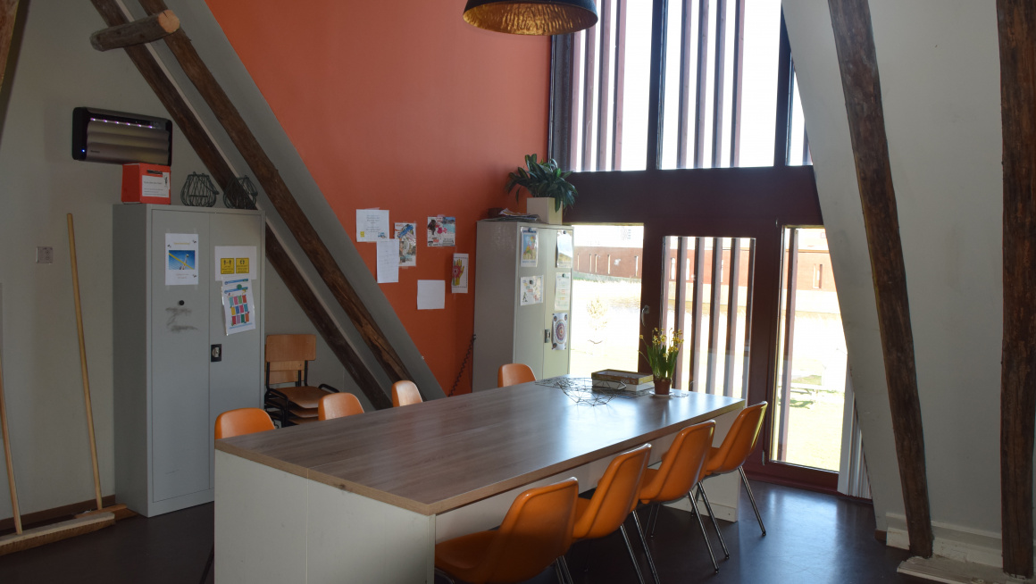 tafel met 8 oranje stoelen voor een raam