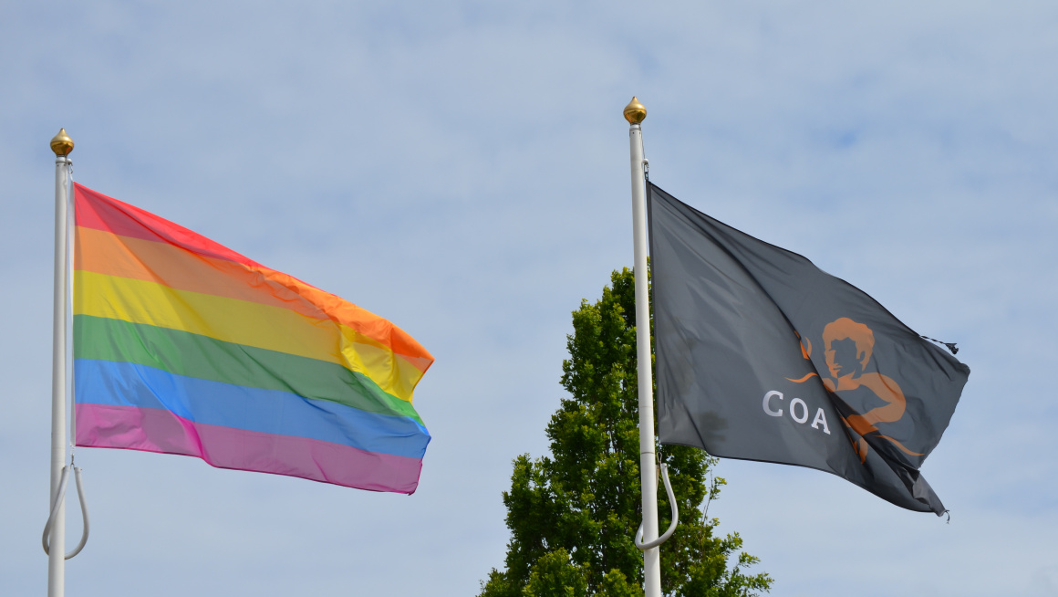 De Regenboogvlag naast de COA-vlag (op het azc in Katwijk)