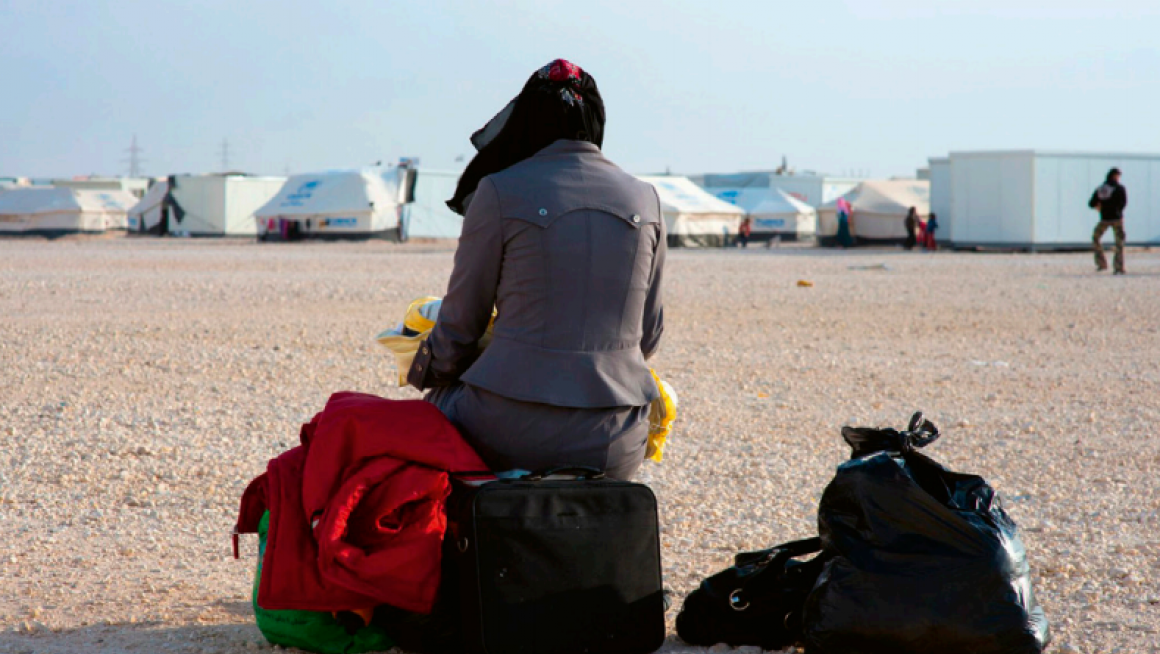 Vrouw met haar bagage in vluchtelingenkamp