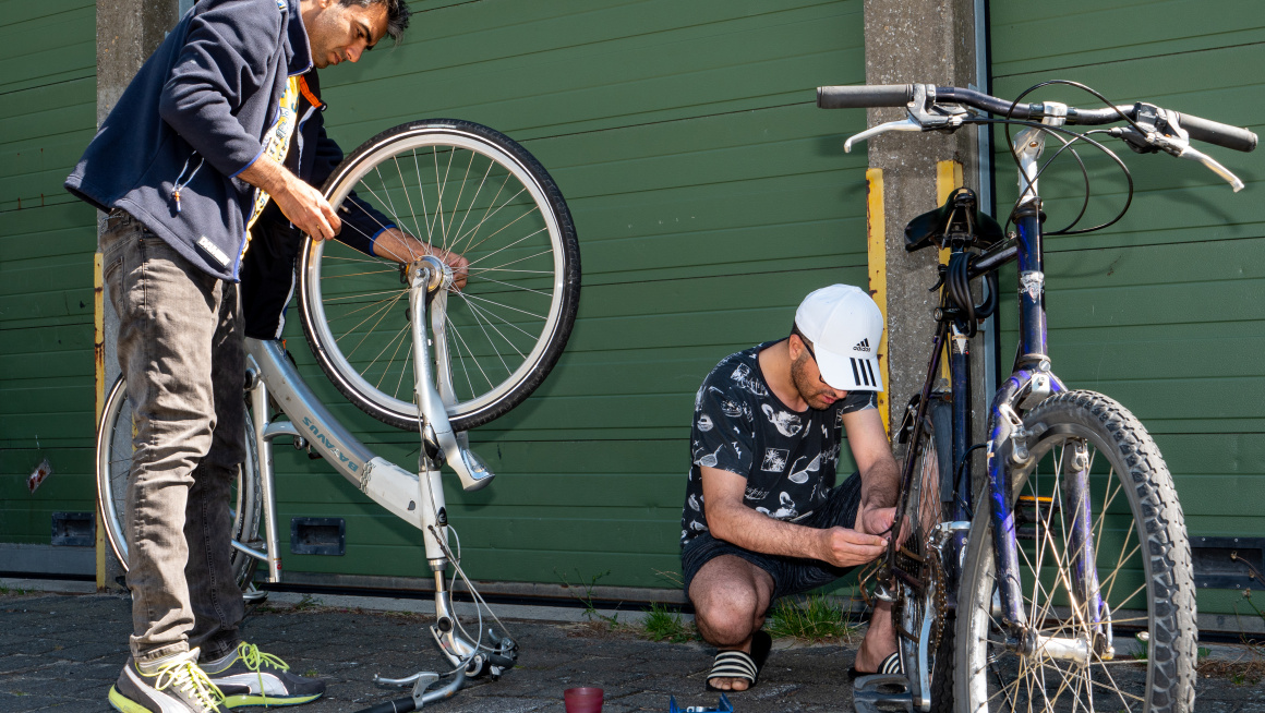 Twee bewoners sleutelen aan fietsen