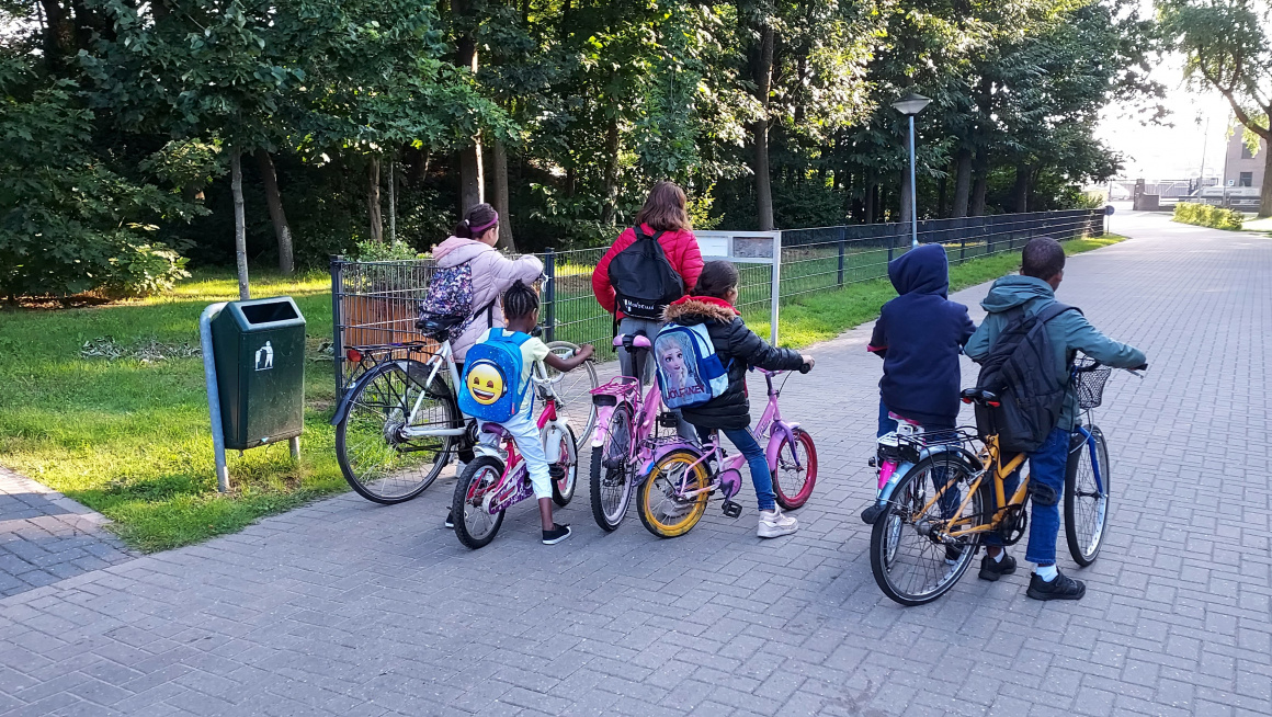 6 kinderen staan klaar op straat om met de fiets te vertrekken naar school