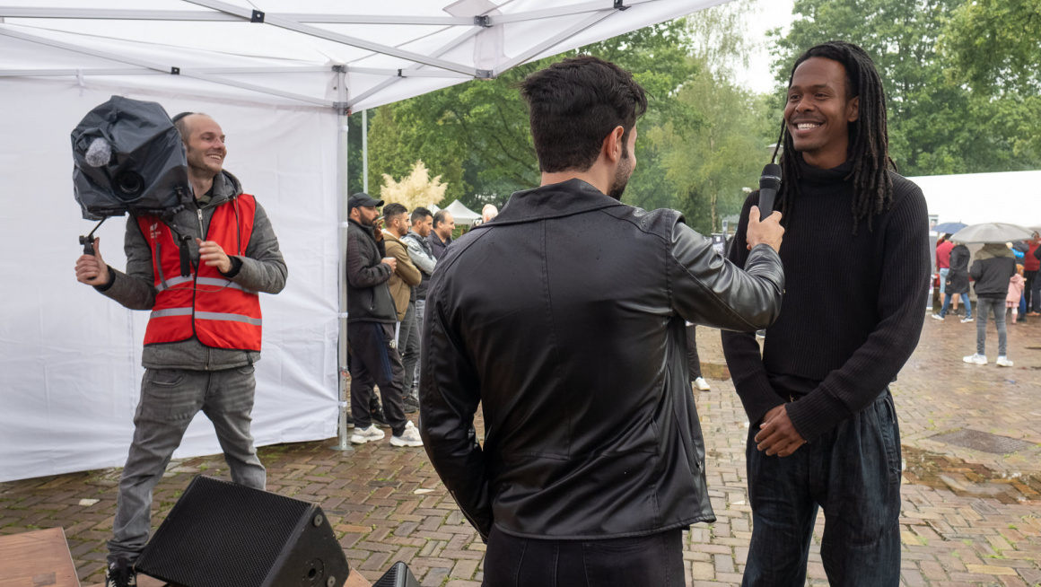 Bewoner interviewt Jeangu Macrooy rijdens Oen  dag in azc Gilze