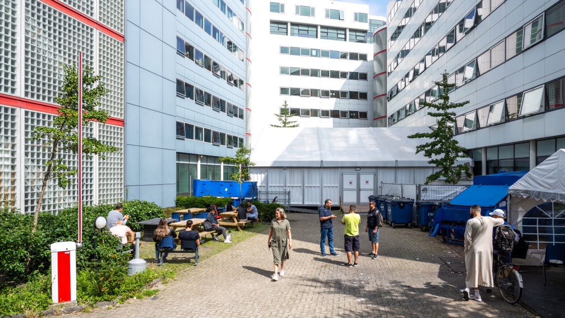 mensen buiten noodopvang gebouw