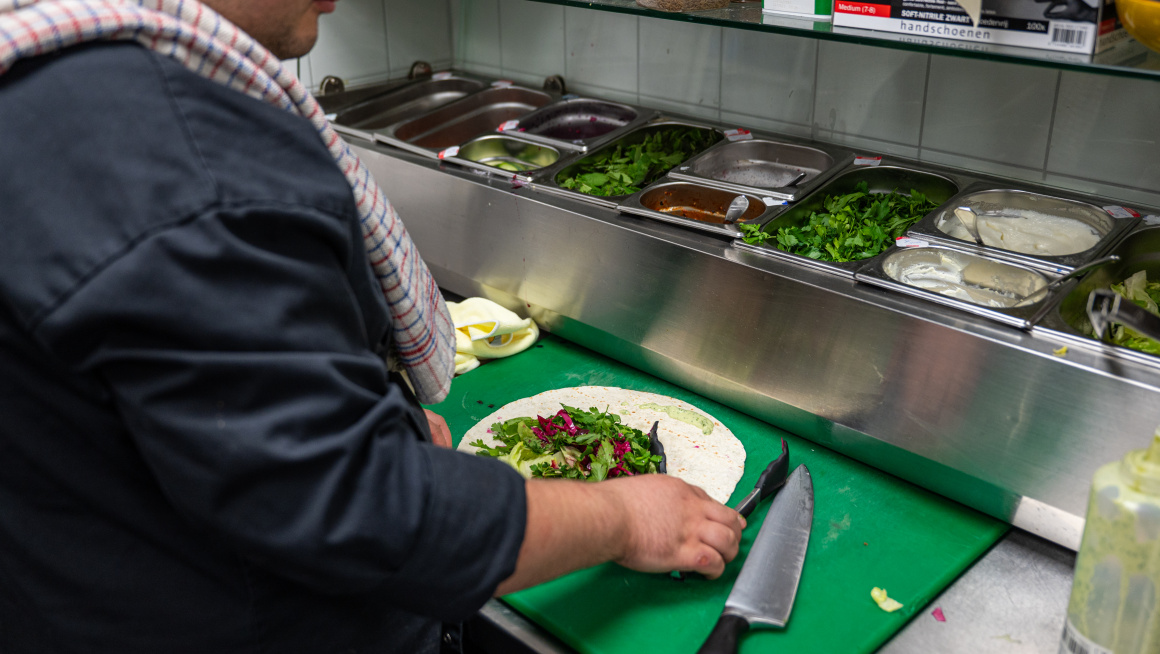 Hossein maakt een wrap in de keuken van A Beautiful Mess