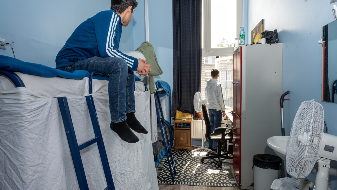 Twee jongens in hun slaapkamer met blauwe muren en een stapelbed