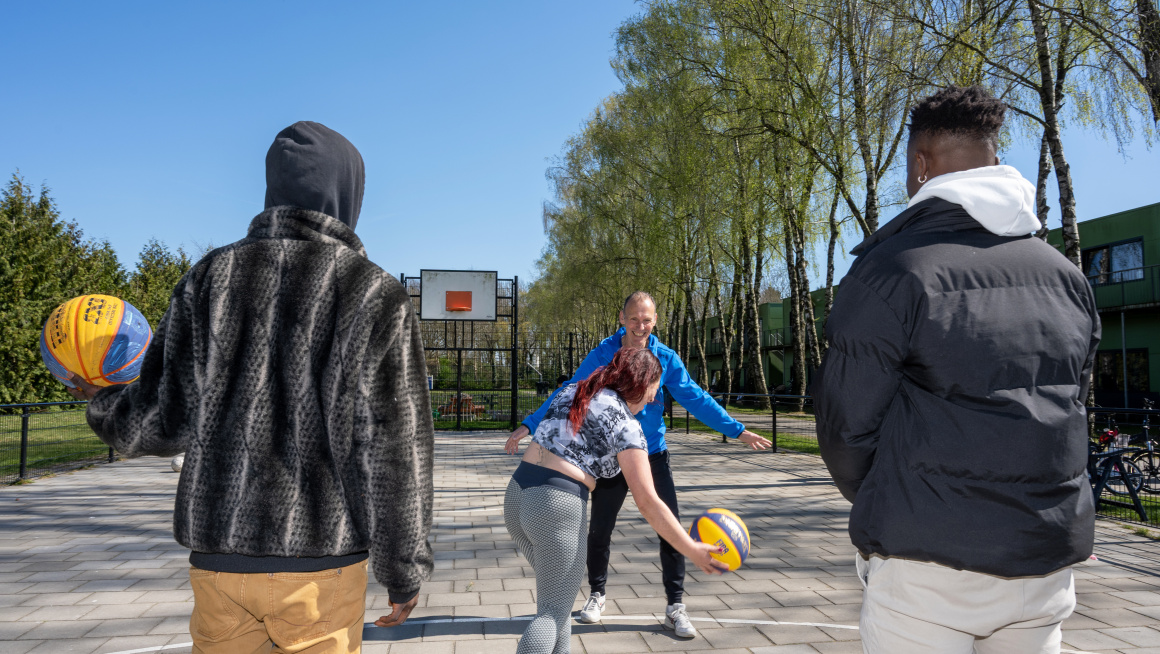 bewoners aan het basketballen met een sportcoach