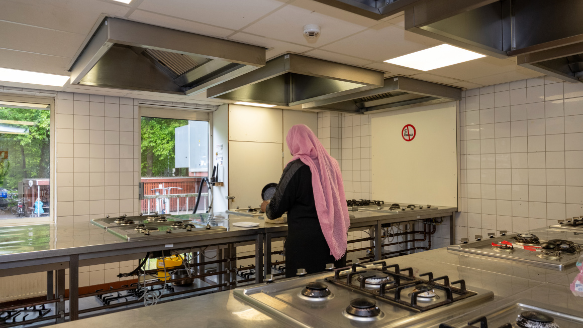 bewoonster in de keuken aan het koken