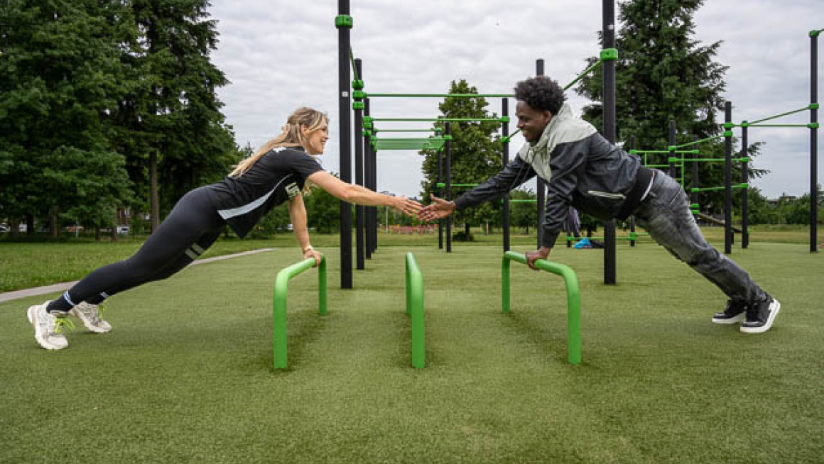 sportcoach en deelnemer sport leunend op attribuut buiten