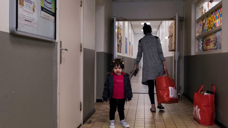 Moeder en kind met boodschappen in het azc 