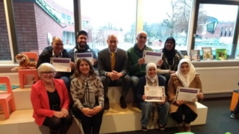 groep mensen poseert met certificaat