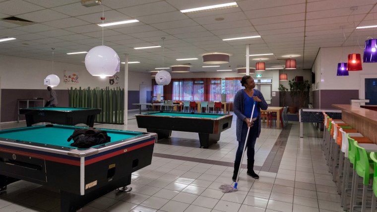 Een bewoner maakt de recreatieruimte van azc Dronten schoon