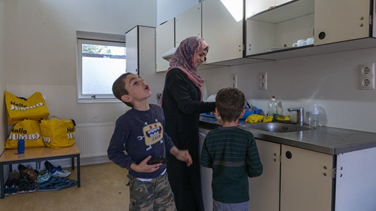 Vrouw met twee kinderen in hun kamer in het azc
