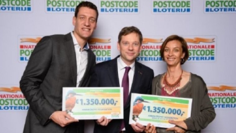 drie mensen houden een cheque vast