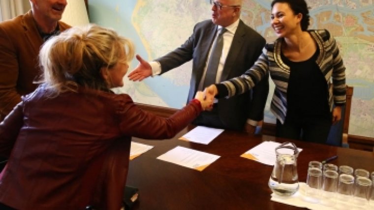 twee vrouwen schudden elkaars hand en twee mannen ernaast ook
