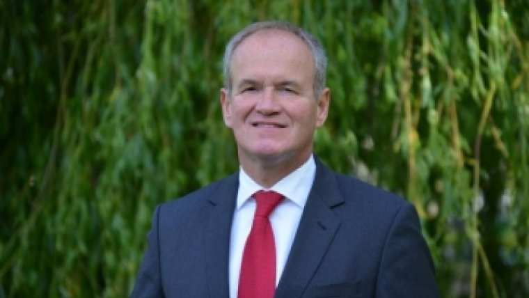 man poseert met rode stropdas