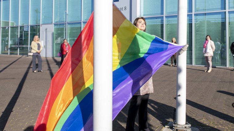 Bahia Tahzib-Lie hangt de Regenboogvlag op bij de Rijnstraat in Den Haag