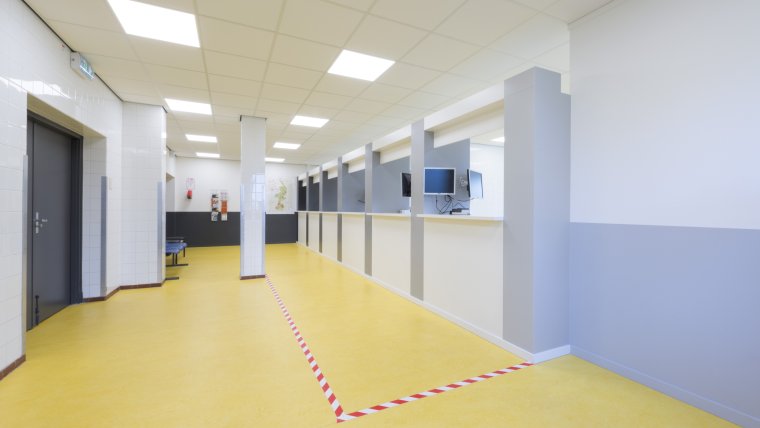 informatiebalie met gele vloer en wit grijze muren